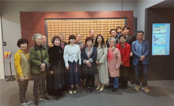 인천시립박물관에 귀중한 유물을 기증한 기증자들. 기증자 명단 앞에서 기념 촬영했다.